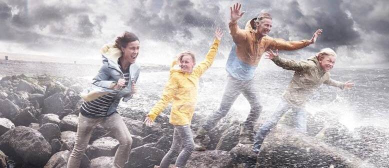 mensen rennen op dijk tegen wind in